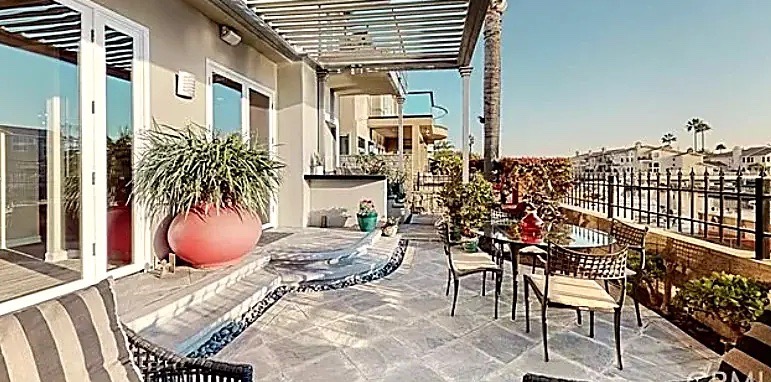 Serpentine tiled water feature winding along a harbor-view terrace with dining seating — Long Beach, CA