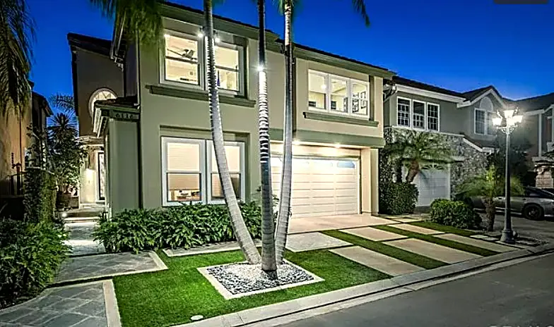 Front landscape at twilight with landscape lighting, palms, and turf-banded walkway — Long Beach, CA