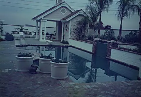 Pool house with covered porch and reflecting pool